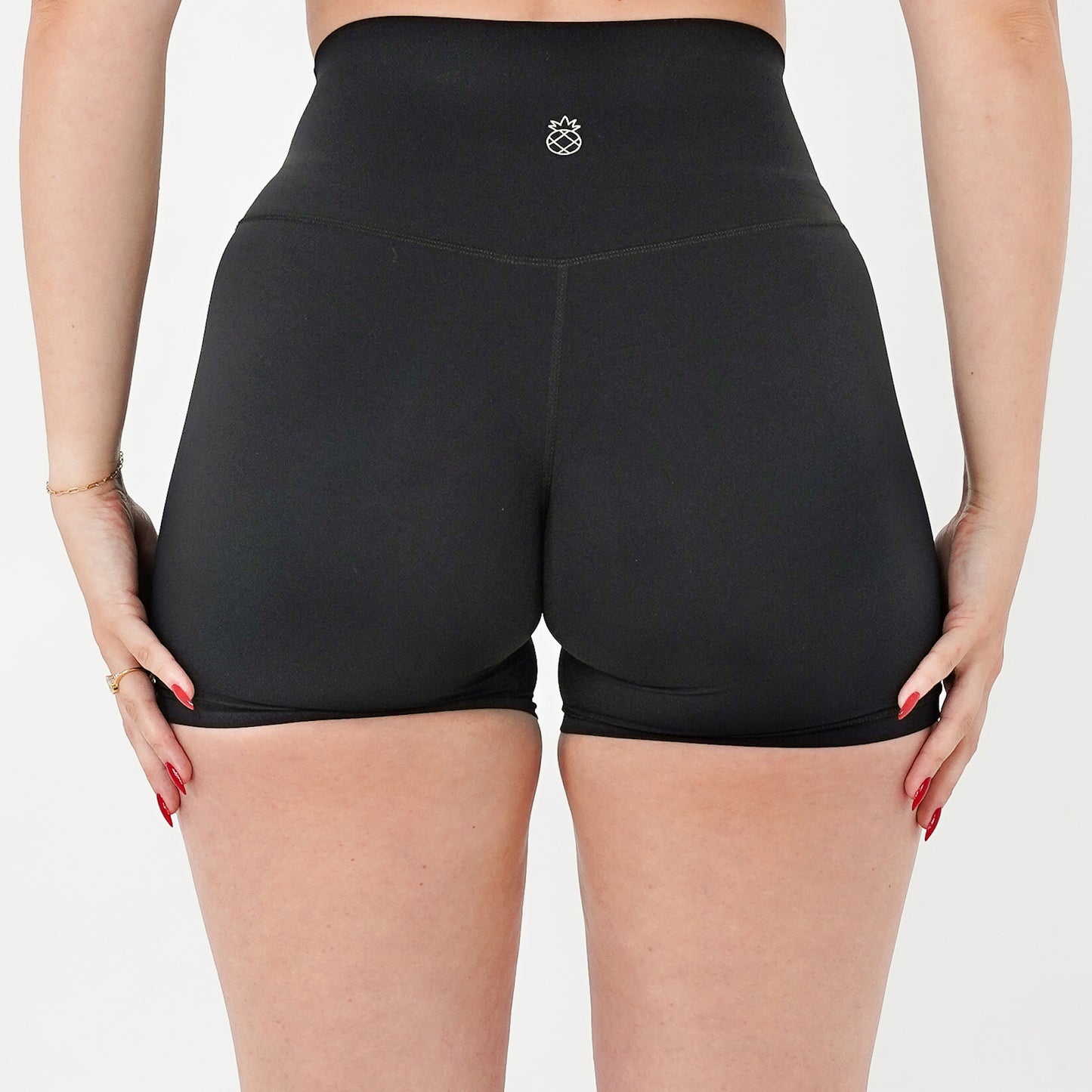 Pineapplebrat founder, influencer Alice Bozinovski, wears the Essential Shorts in Black. Smooth comfort with our 5” inseam shorts—no front seam, high-rise design, and a blend of 80% nylon, 20% spandex for breathability and sculpting. Perfect for all-day wear.