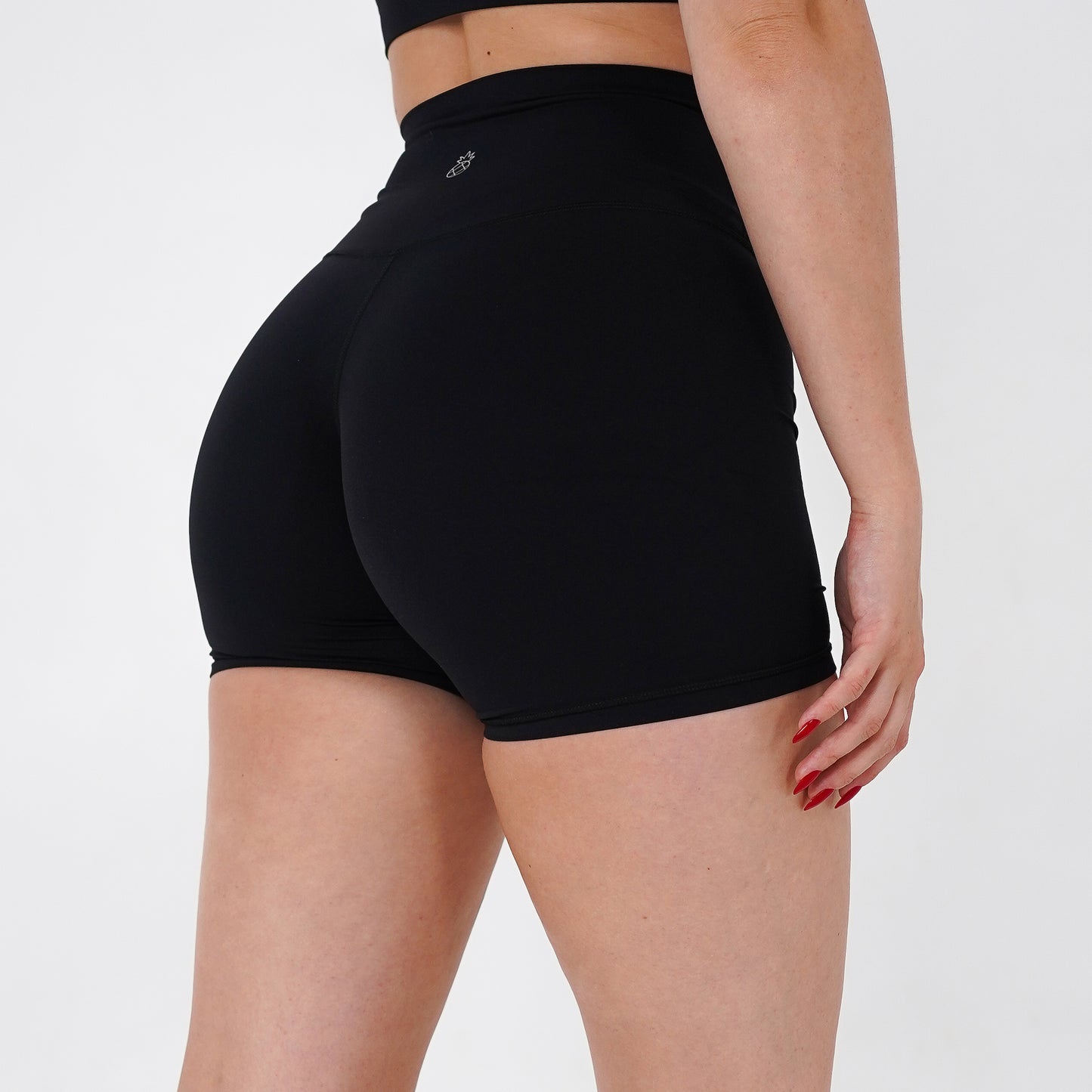 Pineapplebrat founder, influencer Alice Bozinovski, wears the Essential Shorts in Black. Smooth comfort with our 5” inseam shorts—no front seam, high-rise design, and a blend of 80% nylon, 20% spandex for breathability and sculpting. Perfect for all-day wear.