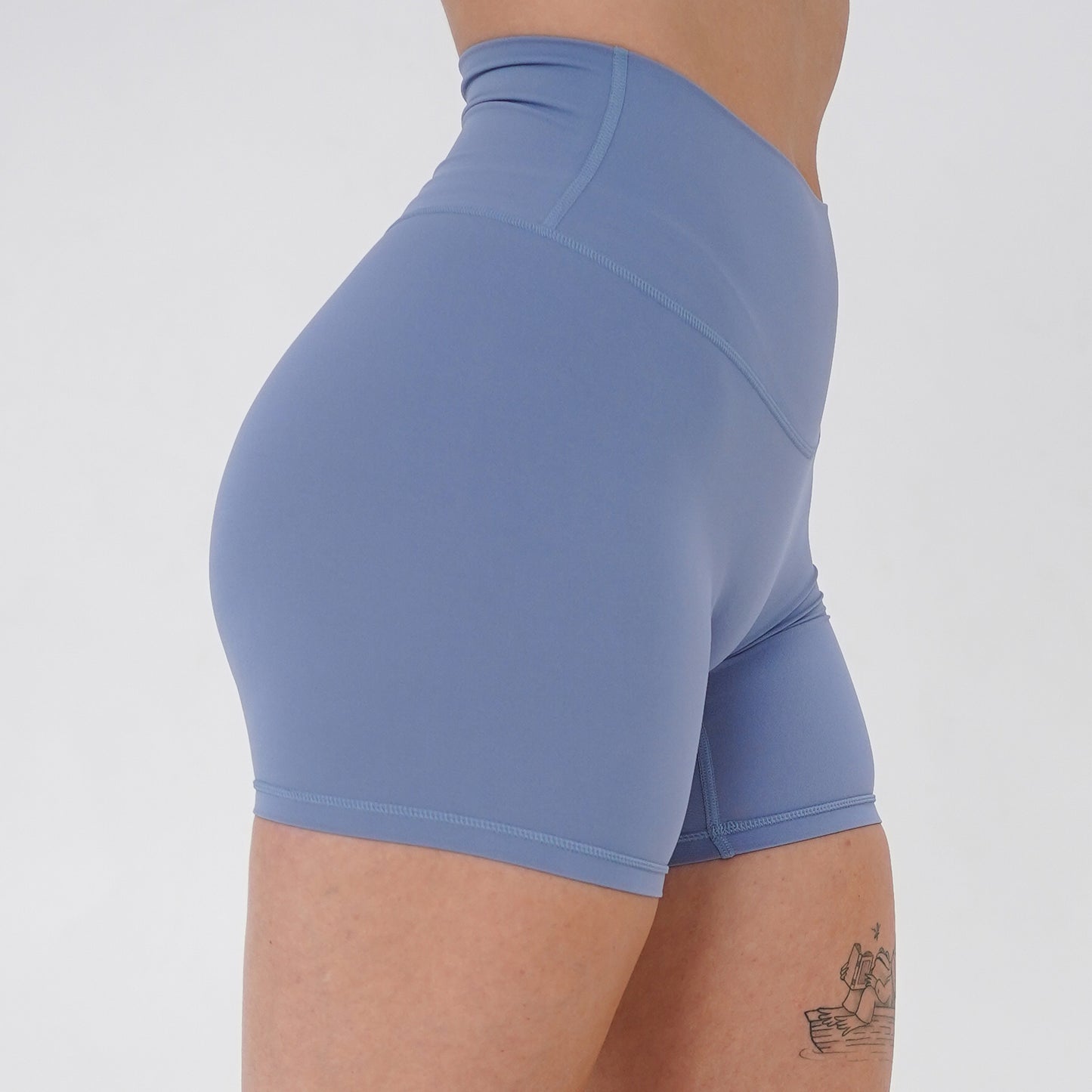 Pineapplebrat founder, influencer Alice Bozinovski, wears the Essential Shorts in Dusted Blue. Smooth comfort with our 5” inseam shorts—no front seam, high-rise design, and a blend of 80% nylon, 20% spandex for breathability and sculpting. Perfect for all-day wear.