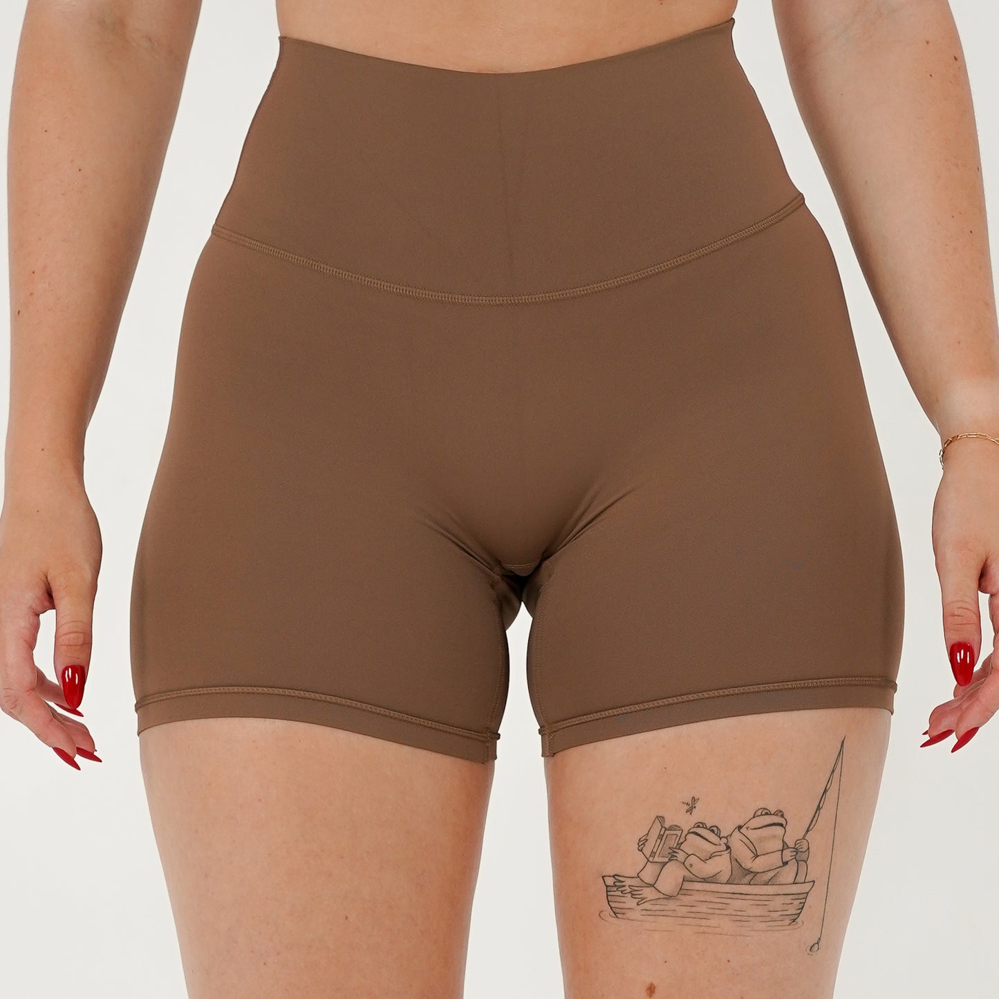 Pineapplebrat founder, influencer Alice Bozinovski, wears the Essential Shorts in Latte. Smooth comfort with our 5” inseam shorts—no front seam, high-rise design, and a blend of 80% nylon, 20% spandex for breathability and sculpting. Perfect for all-day wear.