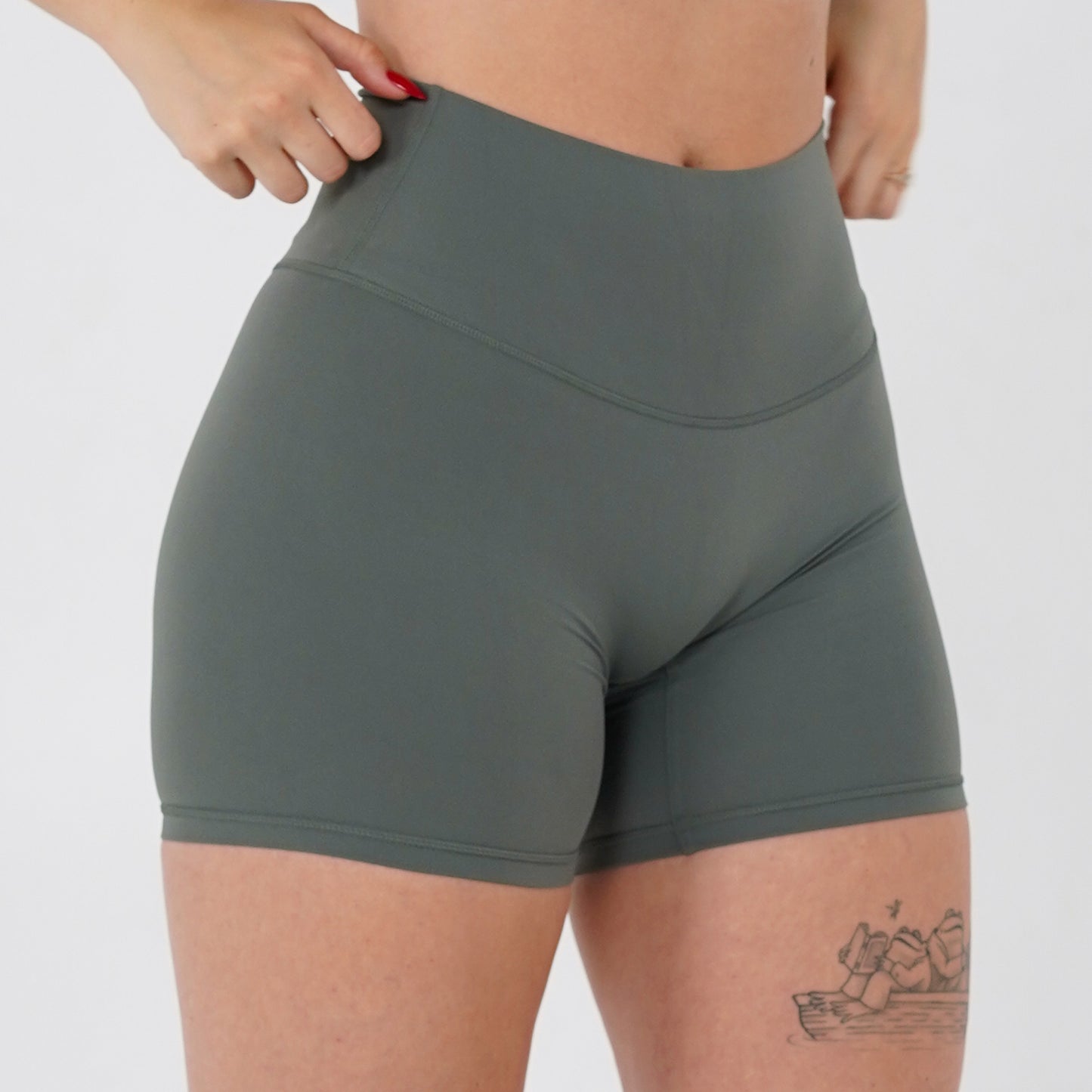 Pineapplebrat founder, influencer Alice Bozinovski, wears the Essential Shorts in Sage. Smooth comfort with our 5” inseam shorts—no front seam, high-rise design, and a blend of 80% nylon, 20% spandex for breathability and sculpting. Perfect for all-day wear.